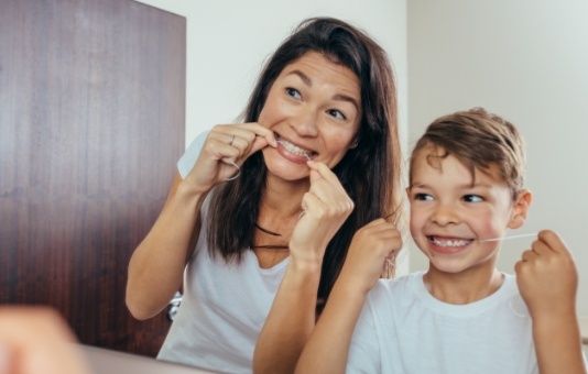 Mother and child flossing to prevent dental emergencies