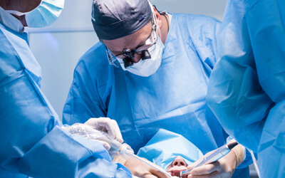 Oral surgeons performing a dental implant surgery