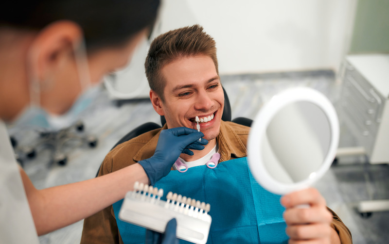 Patient smiling in mirror after cosmetic dentistry